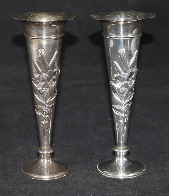 A pair of Edwardian embossed silver trumpet shaped spill vases by William Comyns, London, 1906, 8.25in.